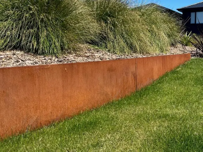 Corner joinery detail of a DIY corten steel retaining wall project.